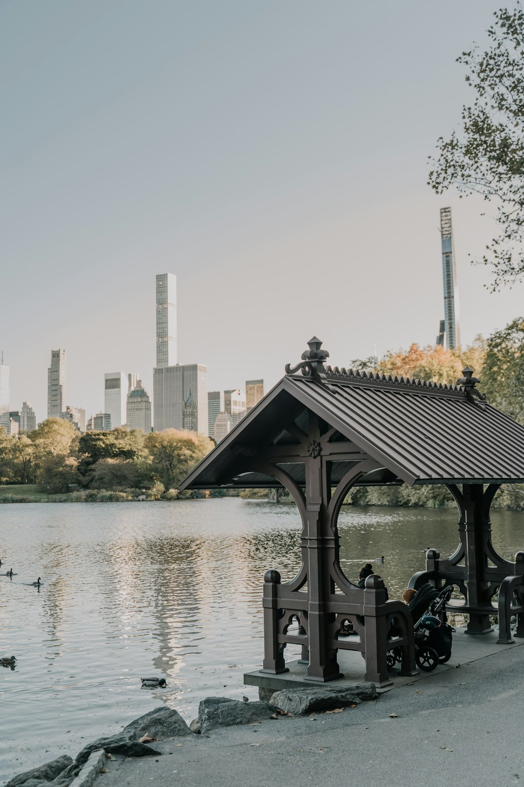 people sitting on black wooden gazebo near body of water during daytime