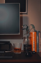 A minimalist desk with a sleek laptop and a cup of tea, bathed in soft bluish-cyan light.