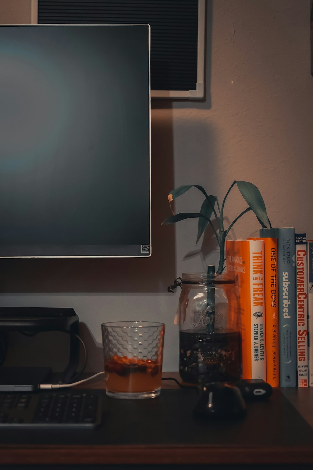 clear drinking glass beside silver flat screen tv