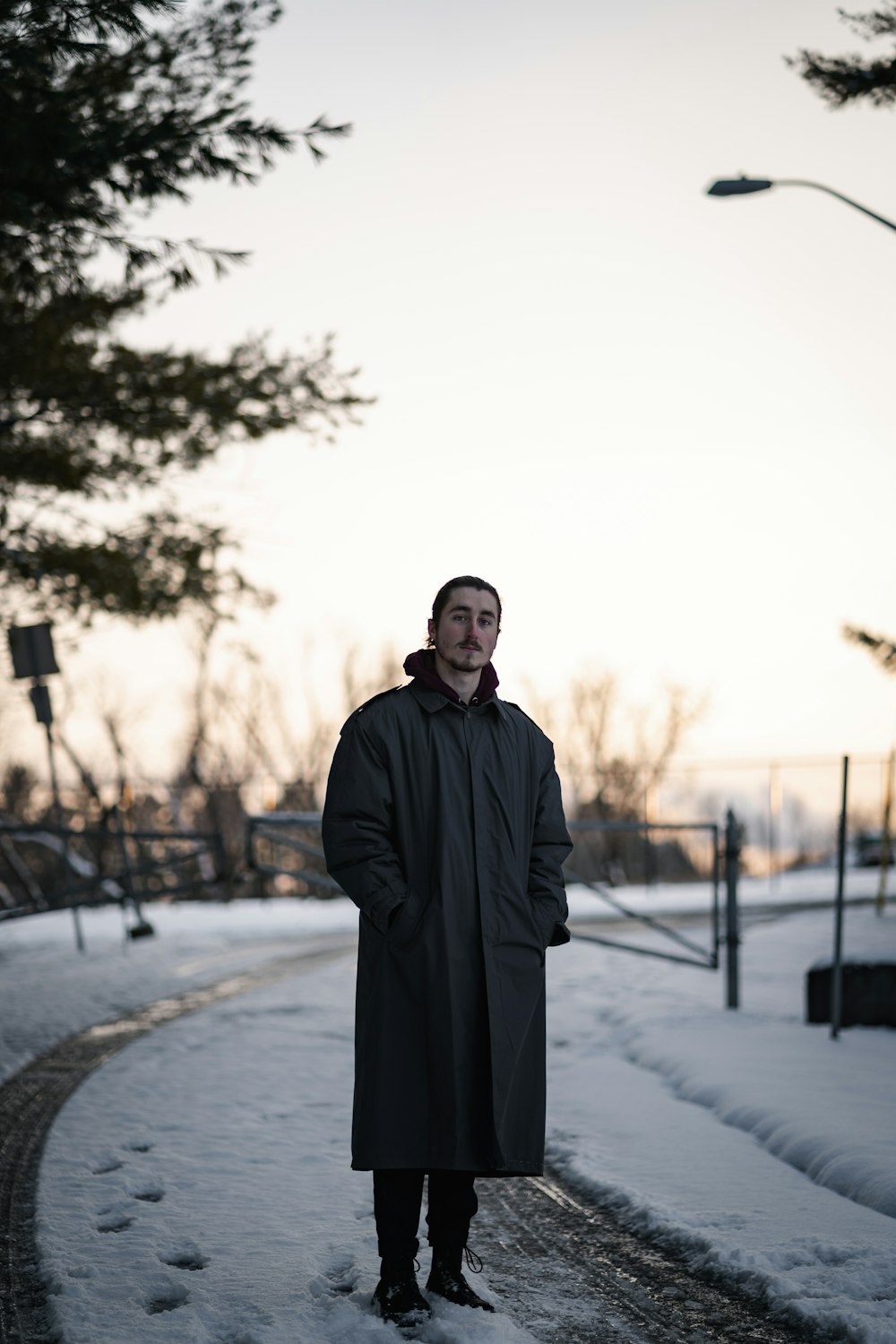 man in black coat standing on road during daytime