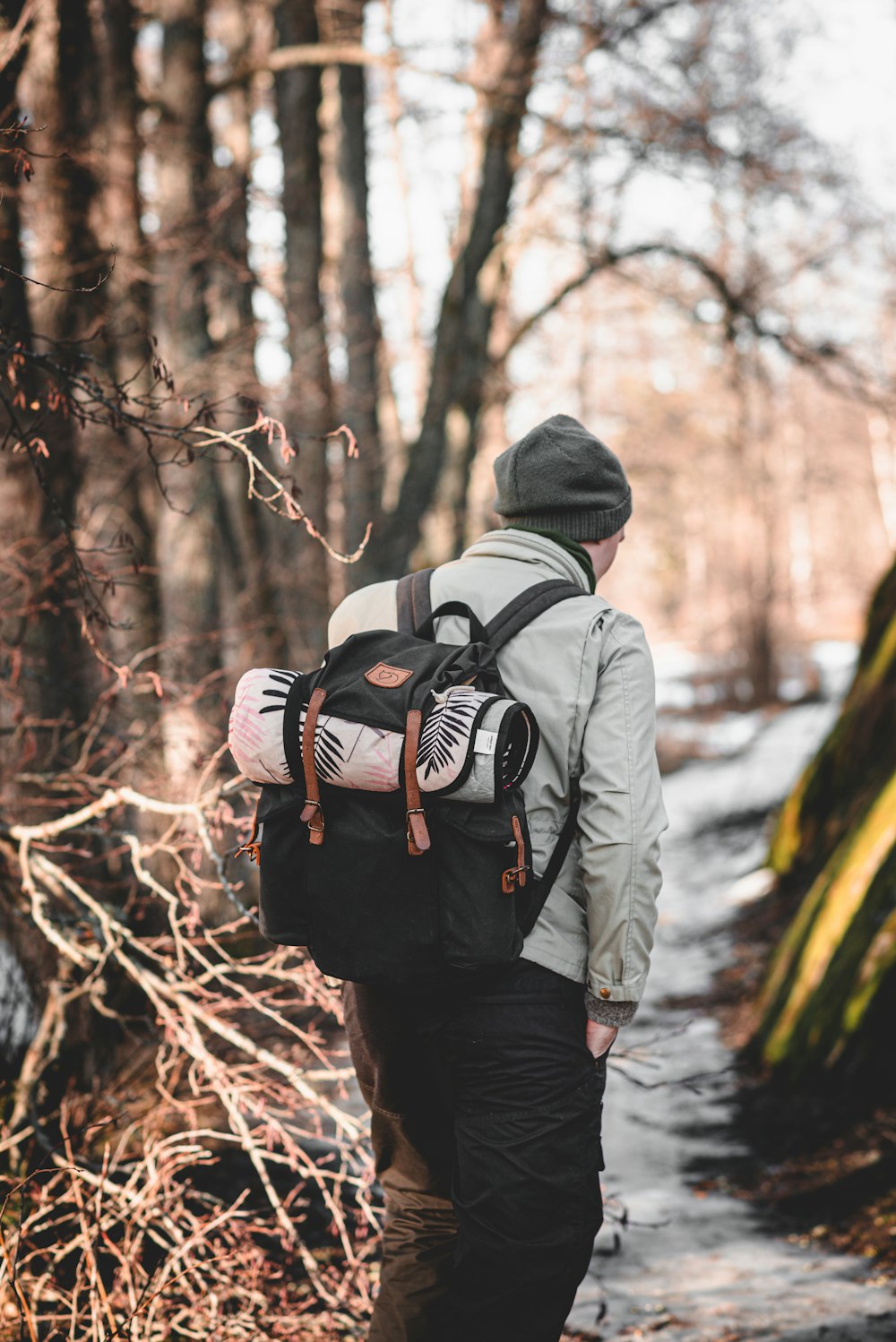 man in black jacket and black knit cap carrying black backpack