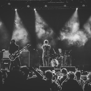 grayscale photo of band performing on stage