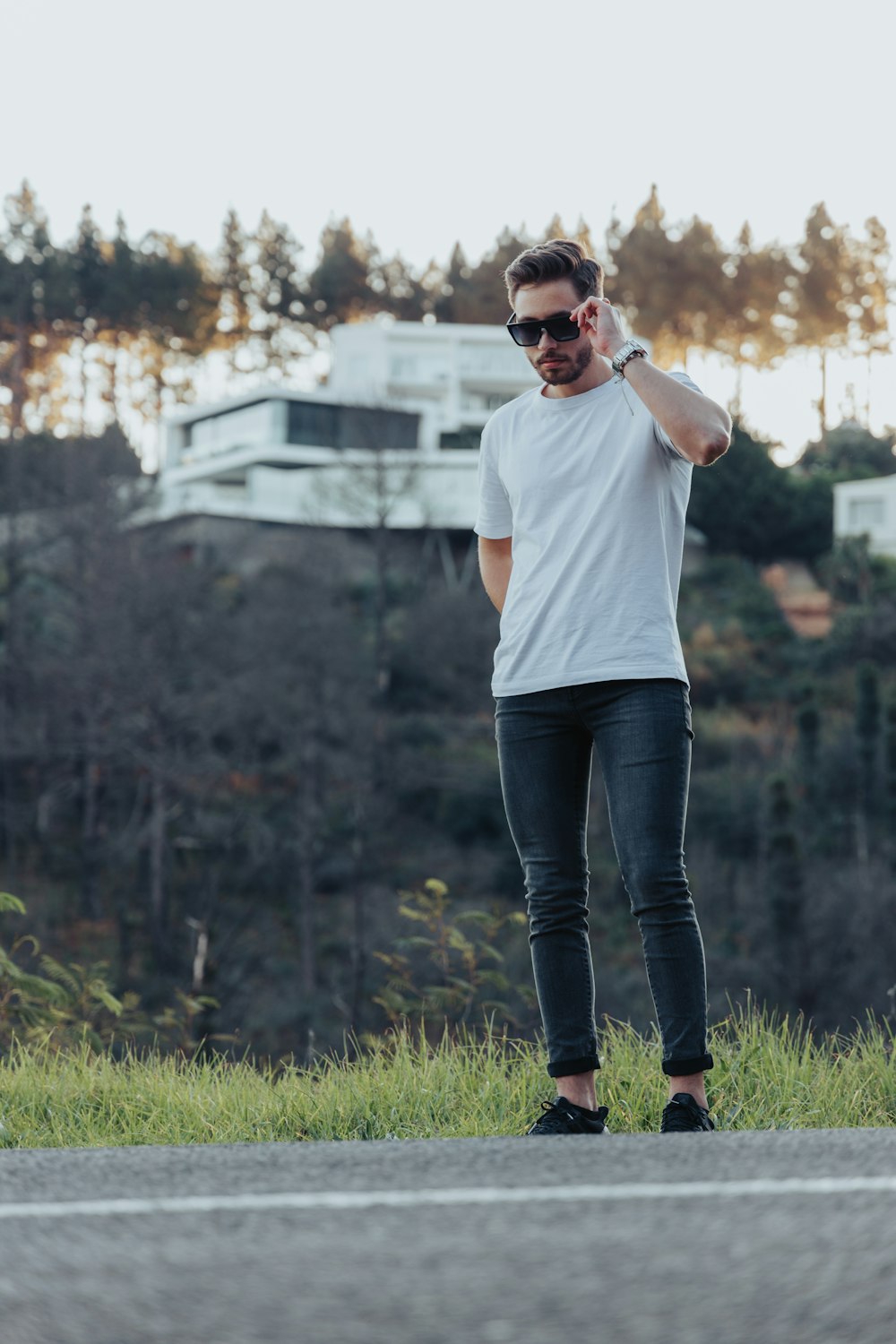 woman in white crew neck t-shirt and blue denim jeans standing on green grass field