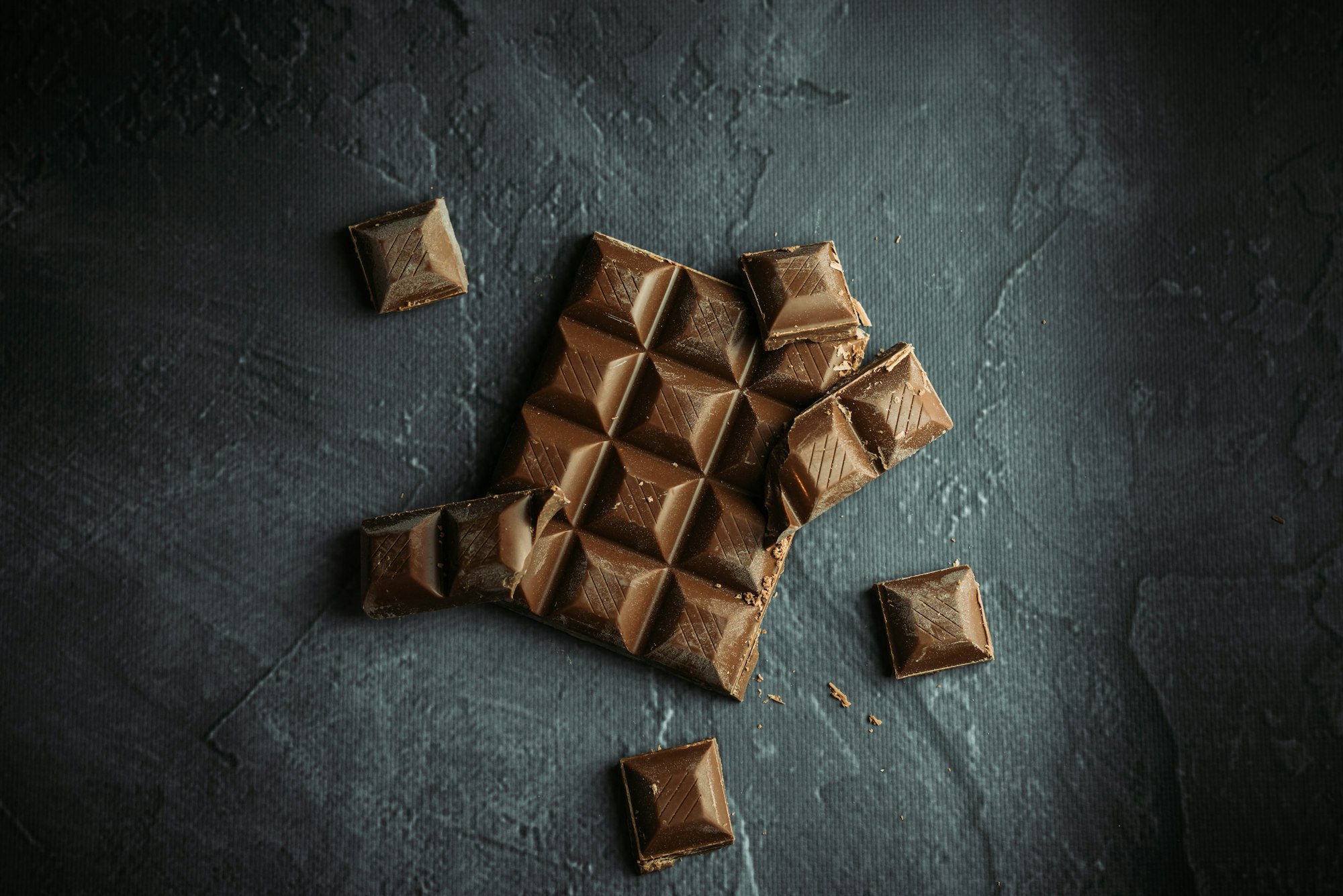 Flat lay food photography of chocolate on black and gray background