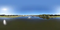 A panoramic view of the 1.7ha central lake reflecting the blue sky.