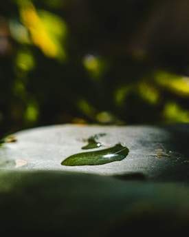 Close-up of a smooth liquid foundation drop on a glass surface reflecting soft light