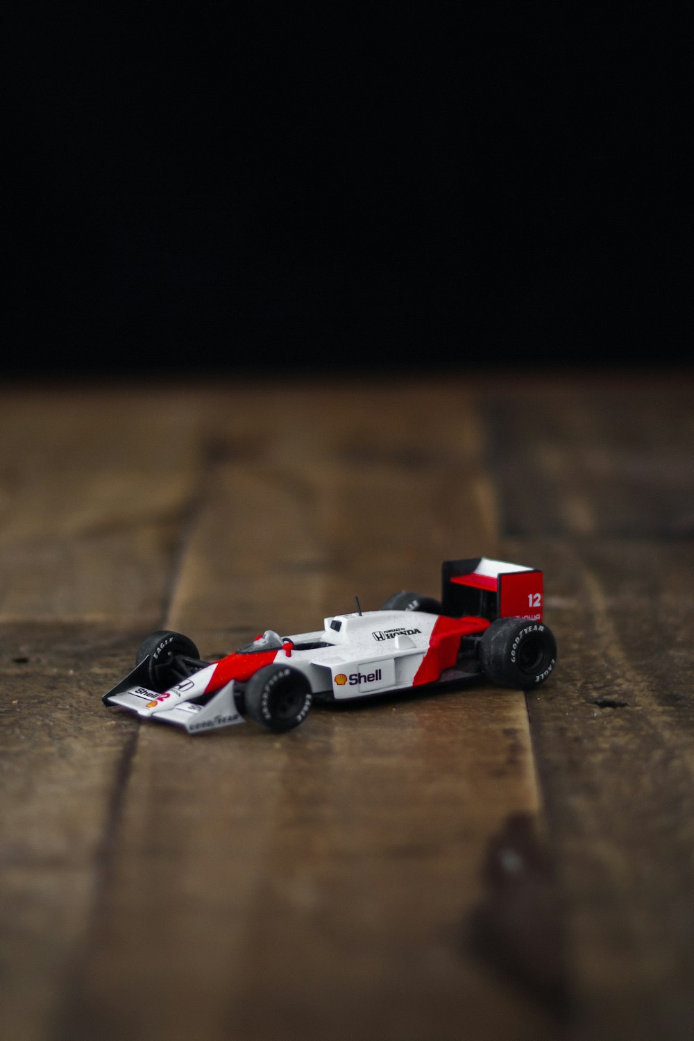 Rot-weißes Lego Auto auf braunem Holztisch