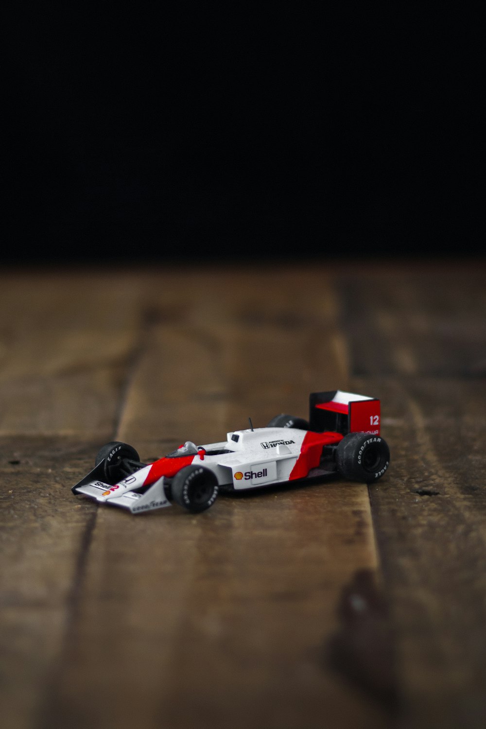 carro de lego vermelho e branco na mesa de madeira marrom