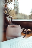 A cozy morning scene with a steaming cup of tea and a book.