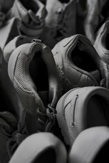 An array of men's shoes in gray tones displayed on a wooden surface.