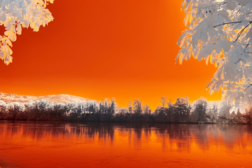 body of water near snow covered mountain during daytime