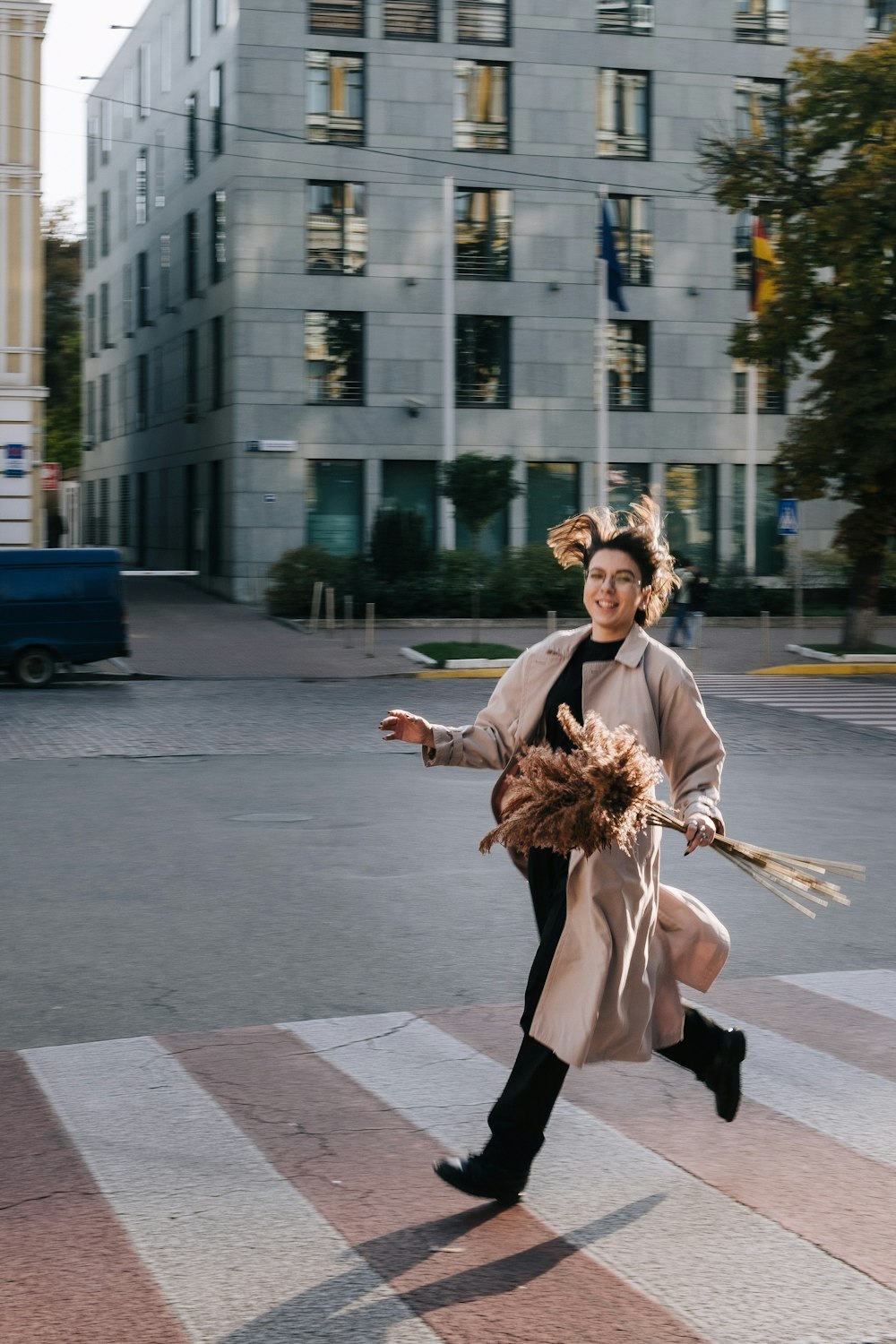 woman in brown coat and black pants walking on sidewalk during daytime