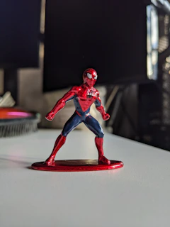 A close-up of a superhero figure with a glossy finish, capturing its dynamic pose.