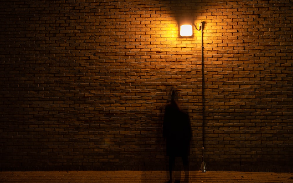 person in black coat walking on street light