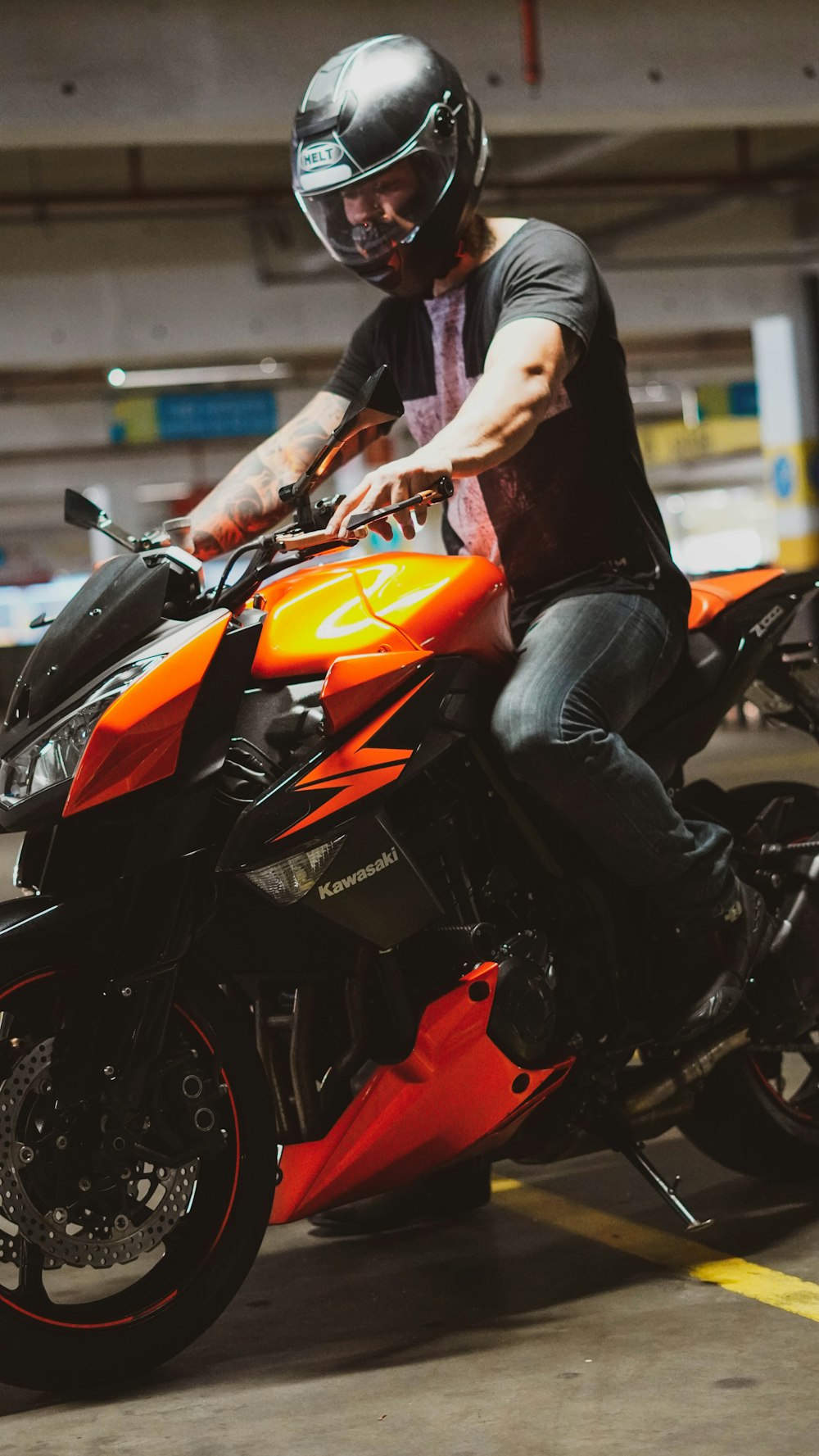 man in black leather jacket riding orange and black sports bike