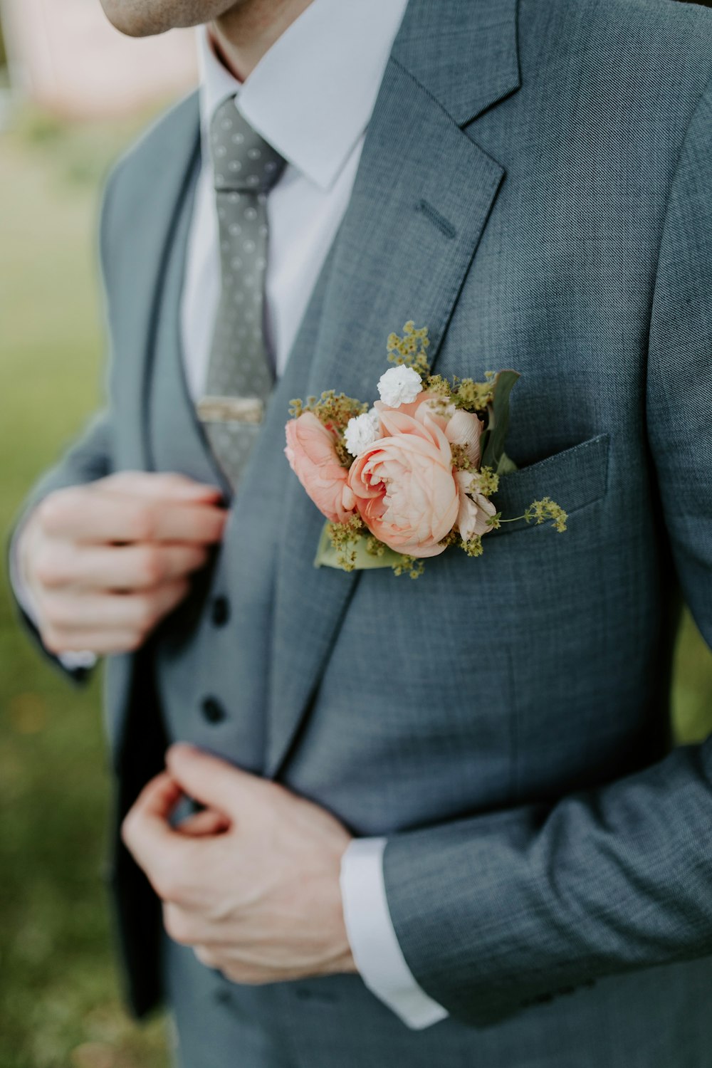 man in black suit holding bouquet of flowers