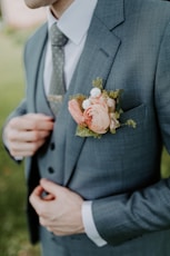 man in black suit holding bouquet of flowers