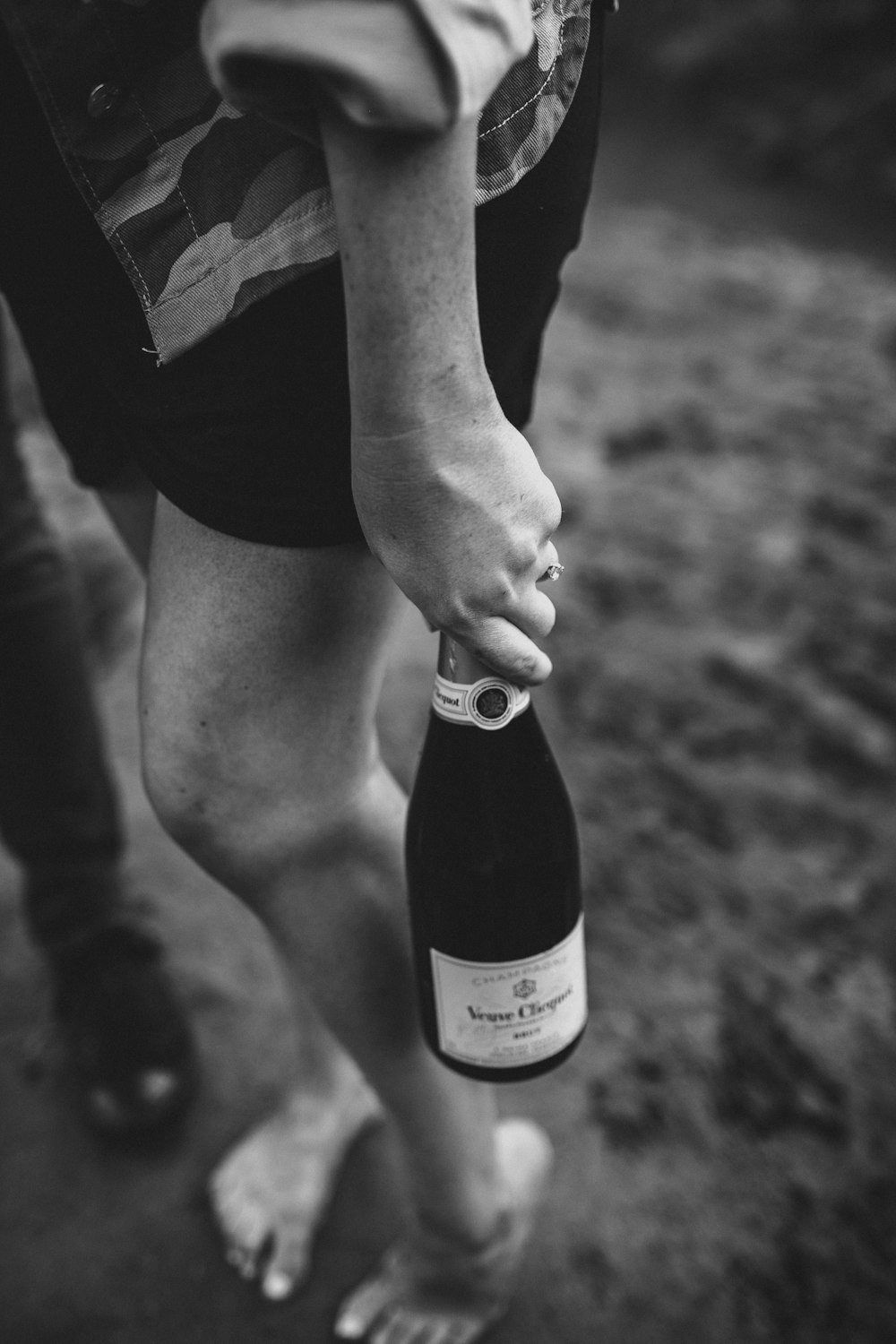 grayscale photo of person holding bottle