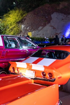Crowd enjoying a nighttime car show with neon signs and synth pop aesthetics in Orlando.