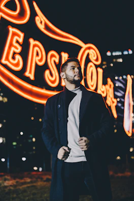 Nighttime shot of a glowing neon sign promoting a new campaign in an urban setting.