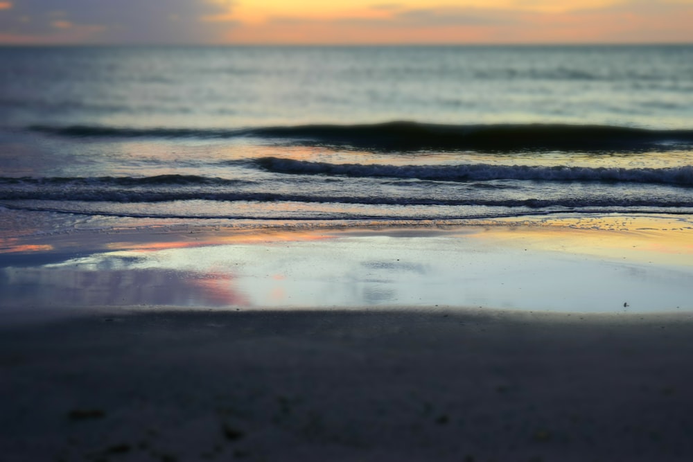 sea waves crashing on shore during sunset