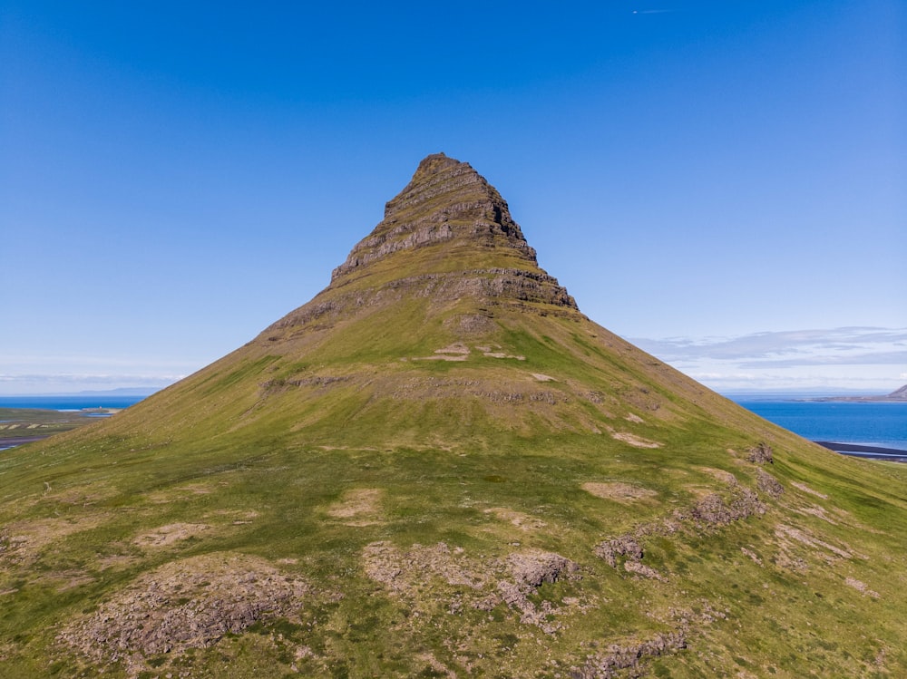 Montaña verde y marrón bajo el cielo azul durante el día