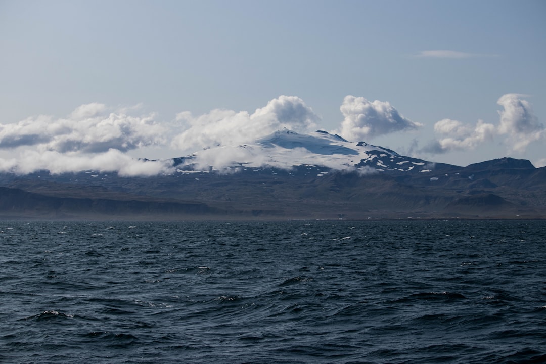 white clouds over snow covered mountain