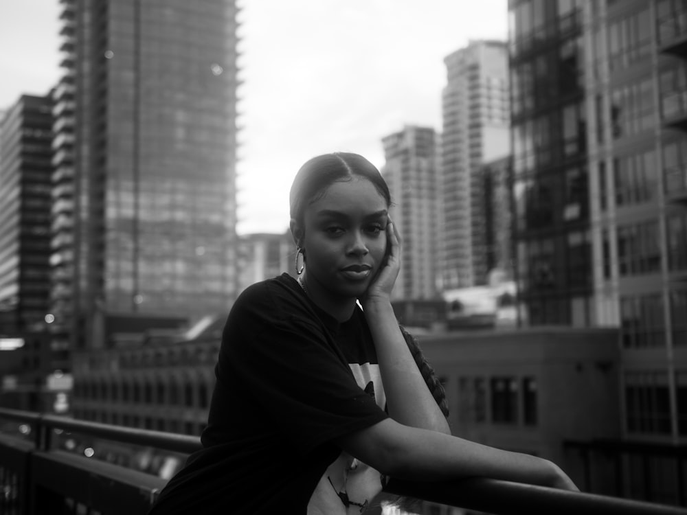 grayscale photo of woman in black dress sitting on bench