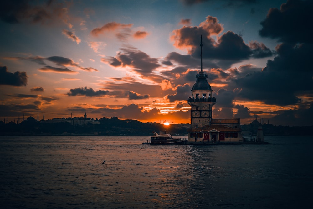 edifício de concreto branco e marrom perto do corpo de água durante o pôr do sol