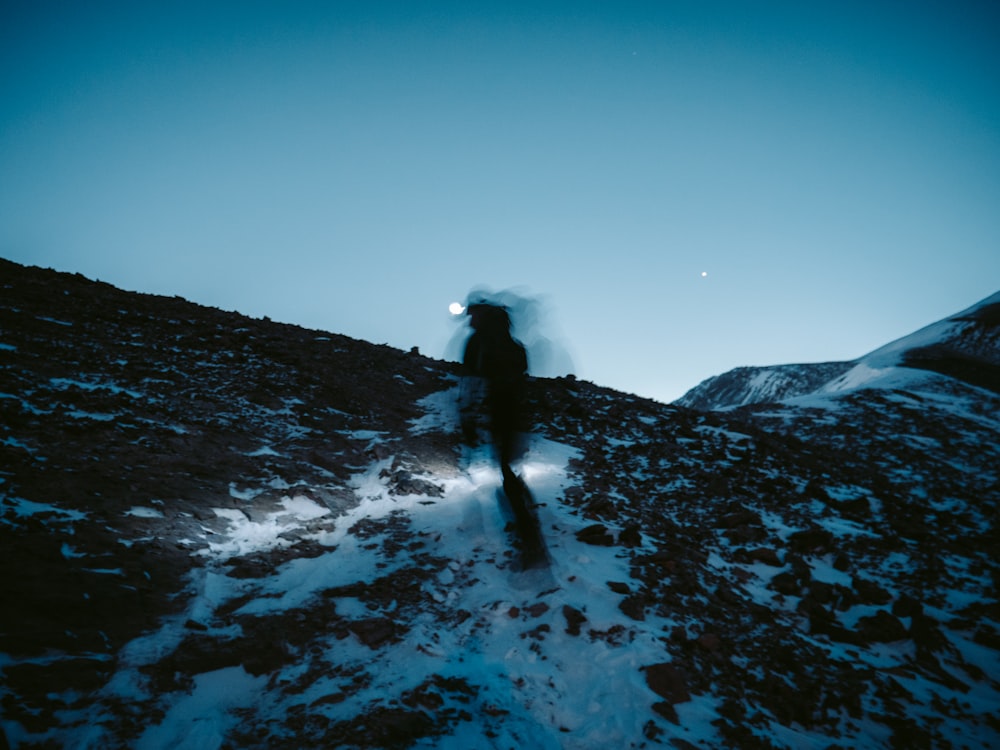 person in black jacket standing on snow covered ground during daytime