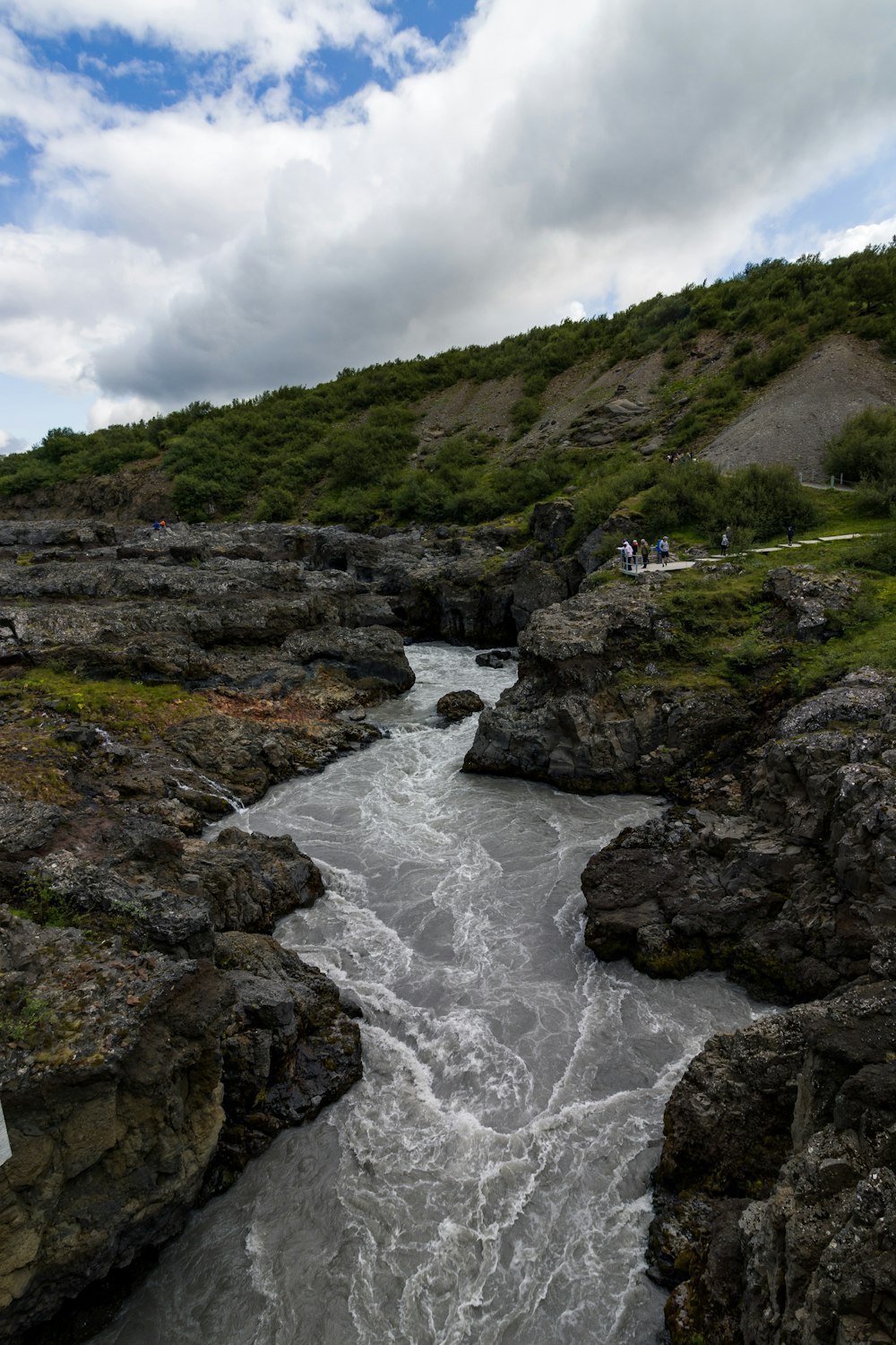 a river running through a lush green hillside