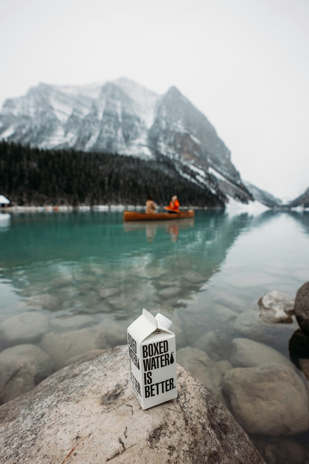 white and orange boat on water near mountain during daytime