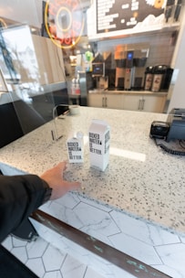 Friendly staff assisting a bar owner with water supply orders.
