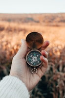 A close-up of hands holding a compass, symbolizing guidance.