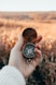 person holding green and gold compass