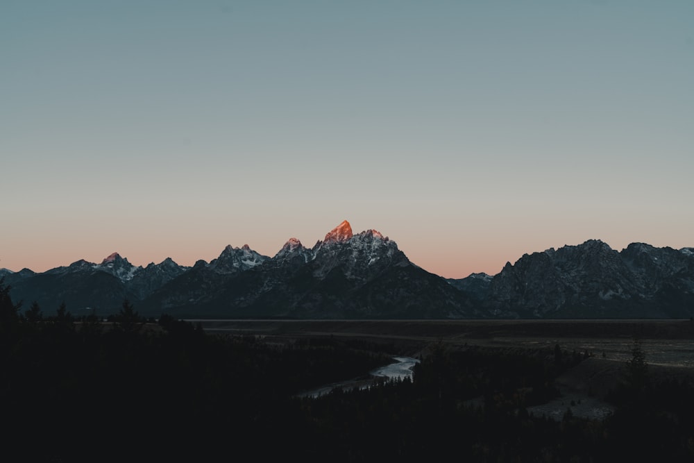 a mountain range with a river in the foreground