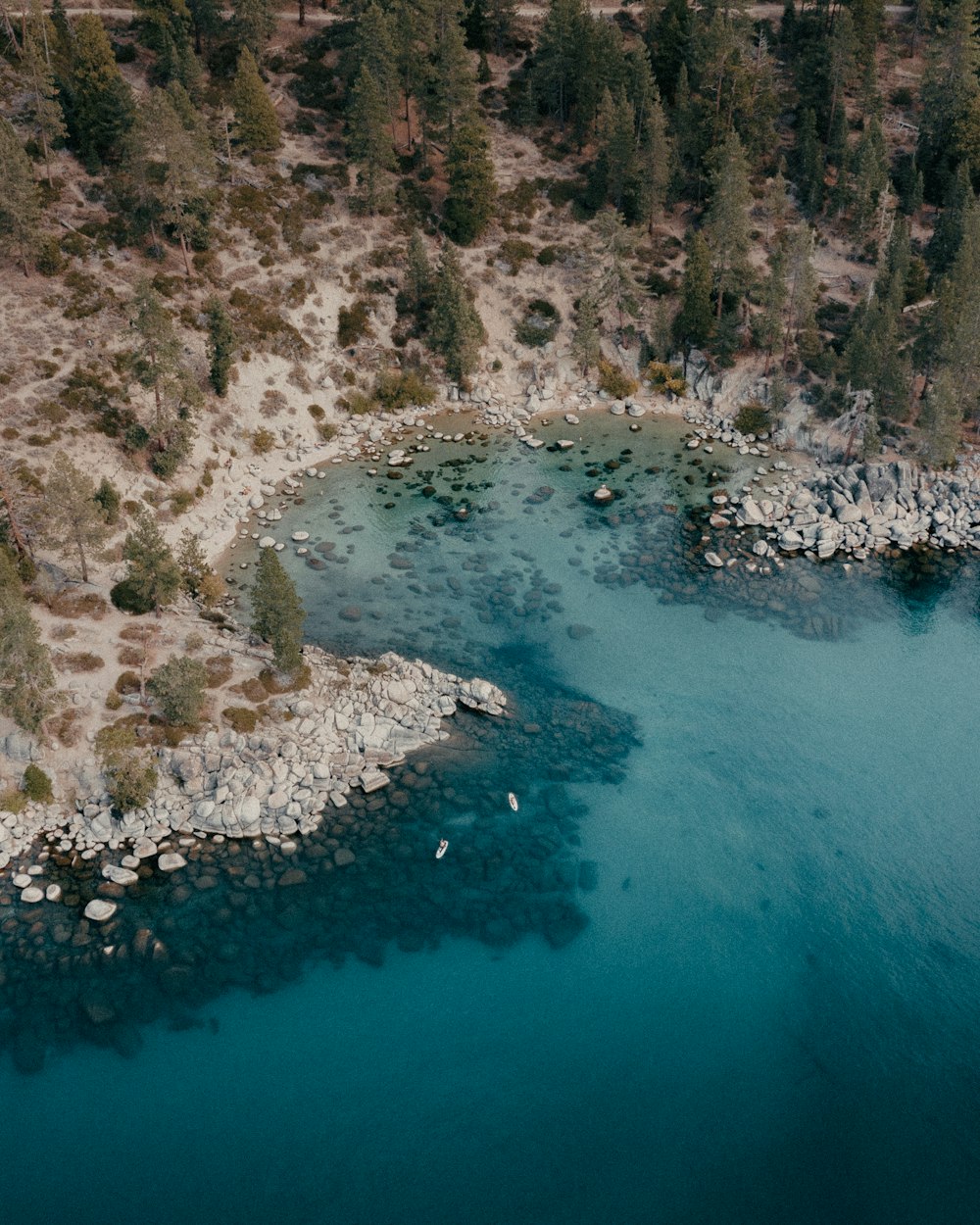 body of water near brown rocky mountain during daytime