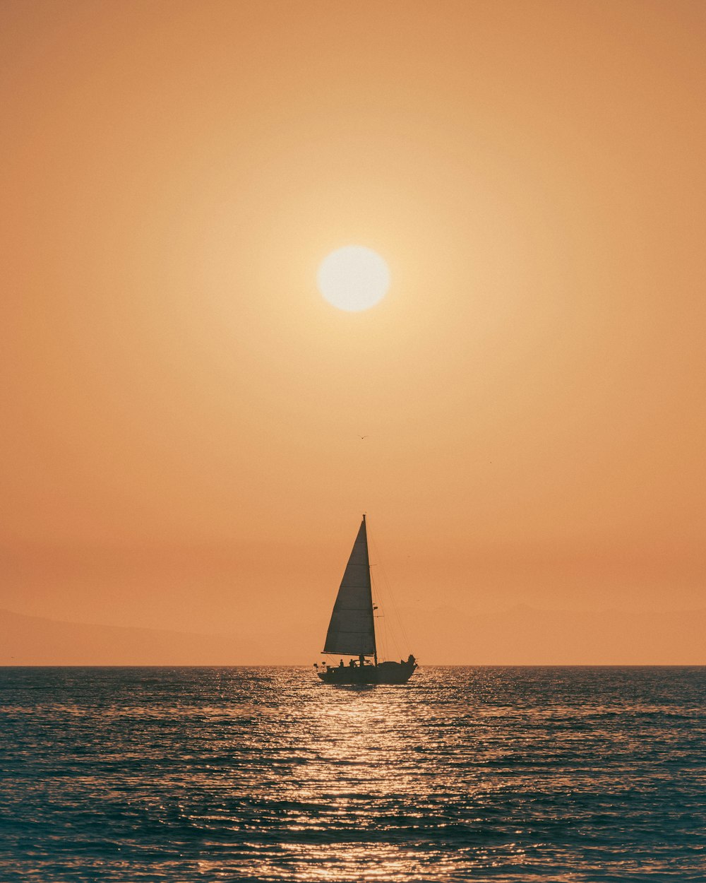 sailboat on sea during sunset