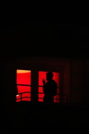 silhouette of man standing near window
