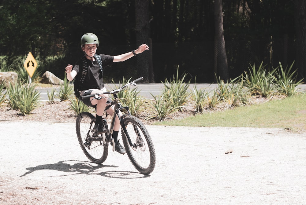 man in black jacket riding on black bicycle during daytime