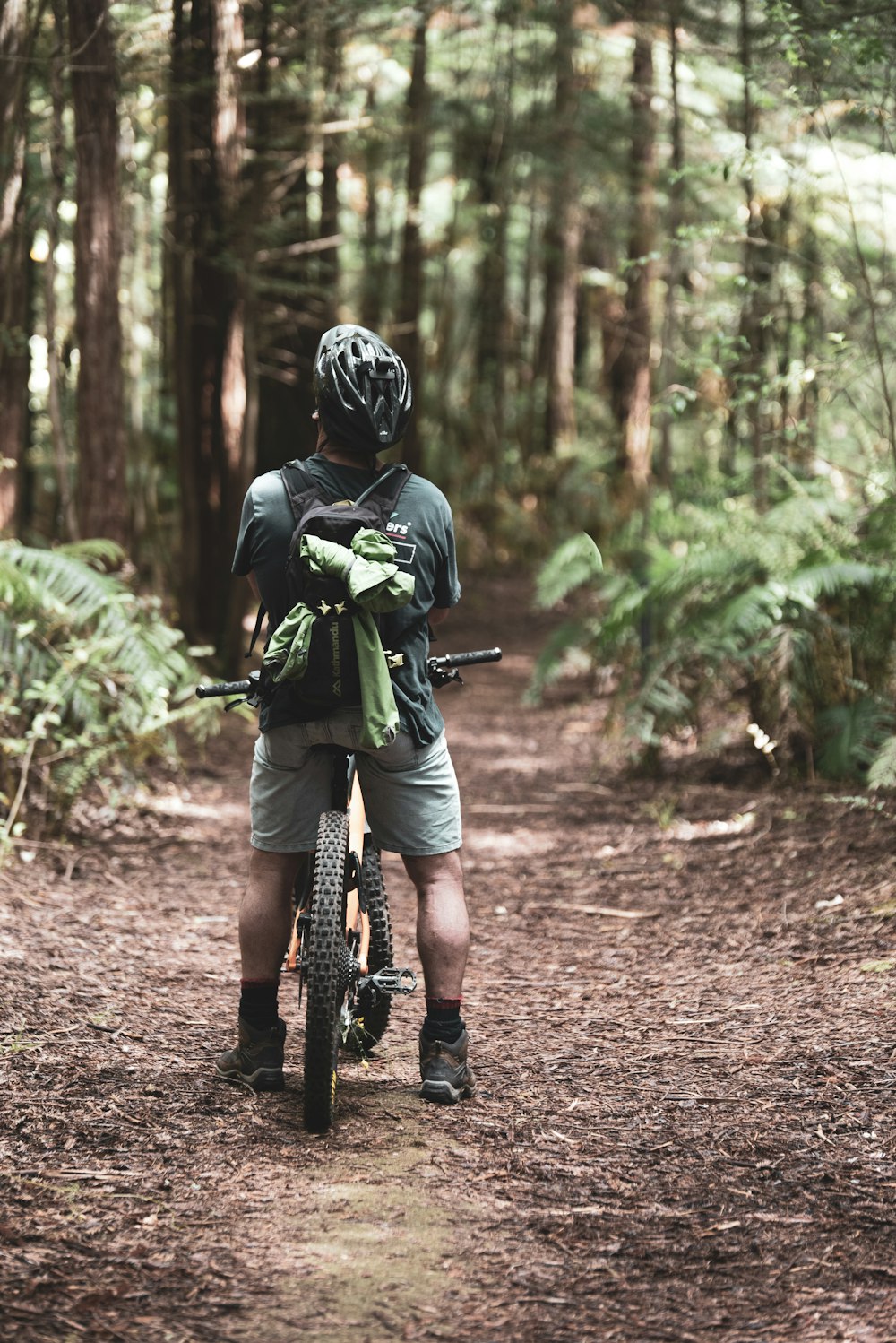 man in green shirt riding bicycle on dirt road during daytime