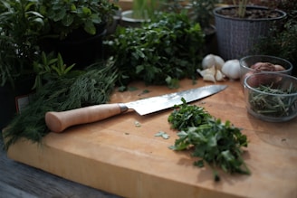 A wooden chopping board with fresh vegetables and herbs arranged on it.