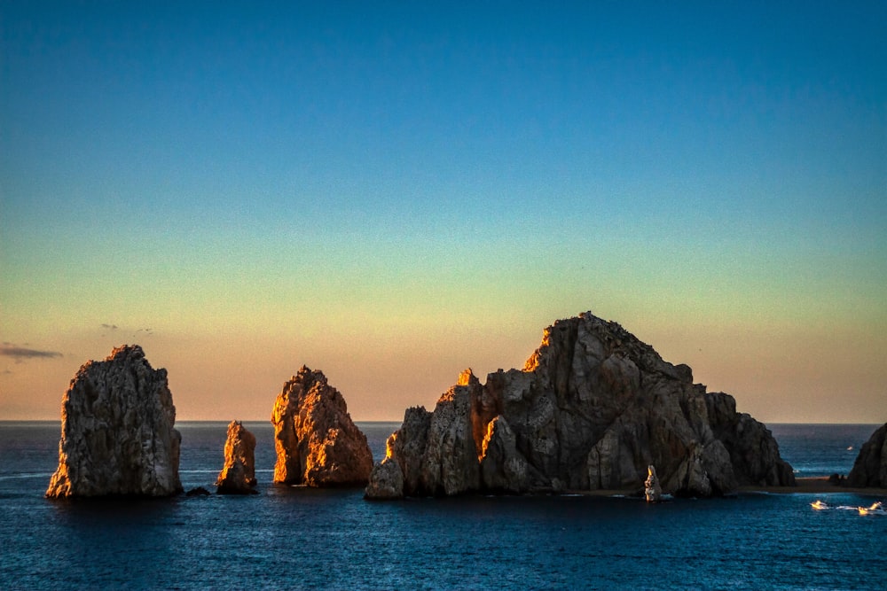 brown rock formation on blue sea under blue sky during daytime