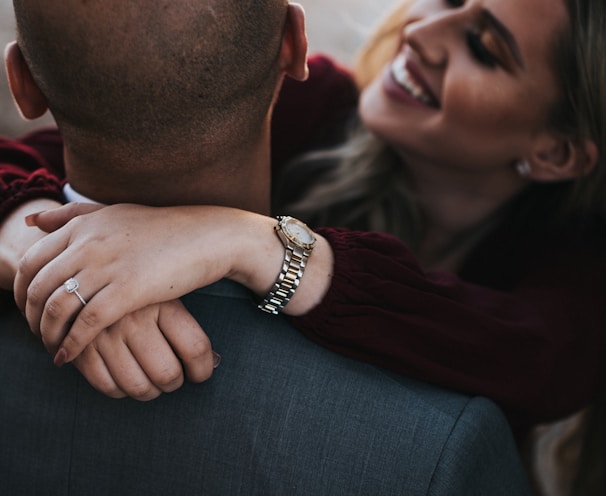 man in black suit jacket kissing woman in red shirt