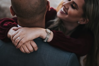 man in black suit jacket kissing woman in red shirt
