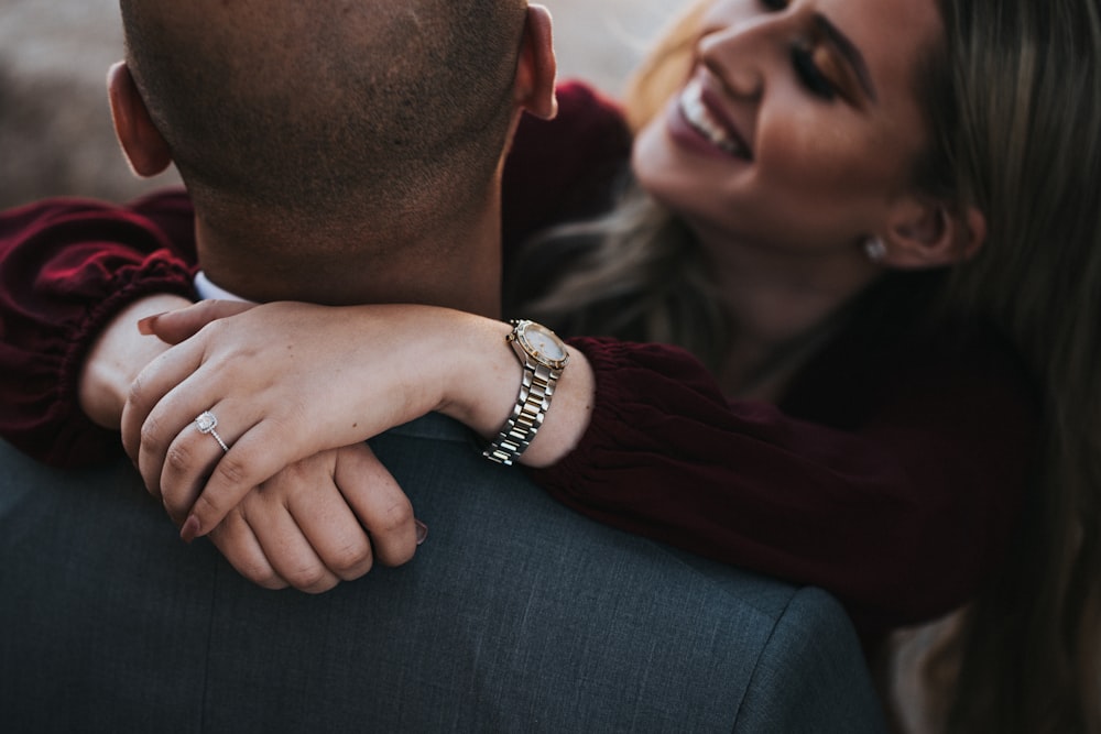 man in black suit jacket kissing woman in red shirt