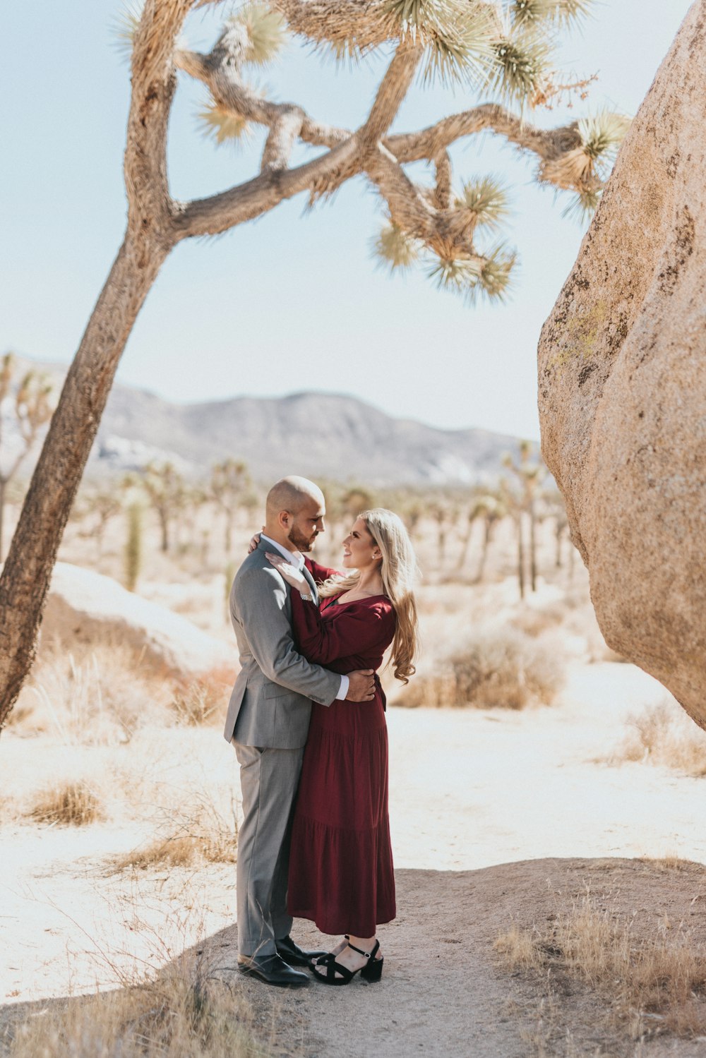 couple kissing near brown tree during daytime