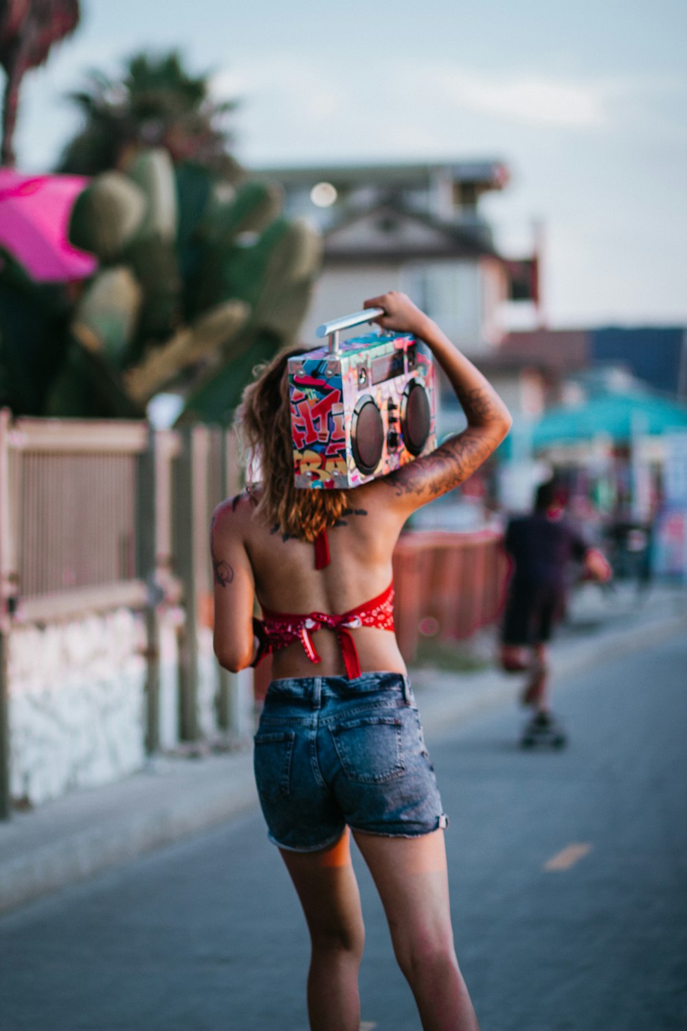 woman in red brassiere and blue denim jeans with white and red mask