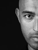 Black and white portrait of a man with intense gaze and textured background.