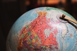 A globe is prominently featured, showcasing North America in detail. The geographic regions are marked in vibrant colors, with states and provinces clearly labeled. There's a metallic meridian ring with a pivot mechanism holding the globe.